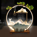 Decorative lamp with mountain, deer, and mist design on a dark background