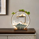 Decorative table lamp with mountain and deer design on a wooden base.