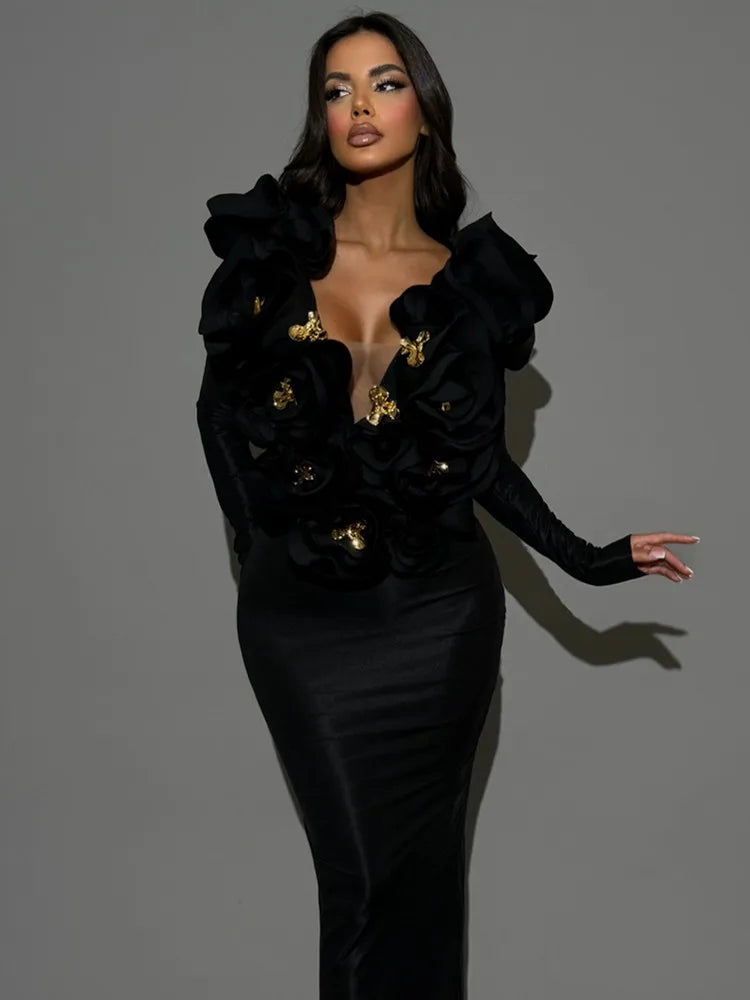 Woman wearing a black dress with gold buttons against a gray background