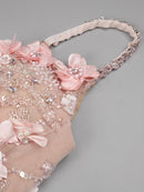 Decorative headband with pink flowers and beads on a gray background