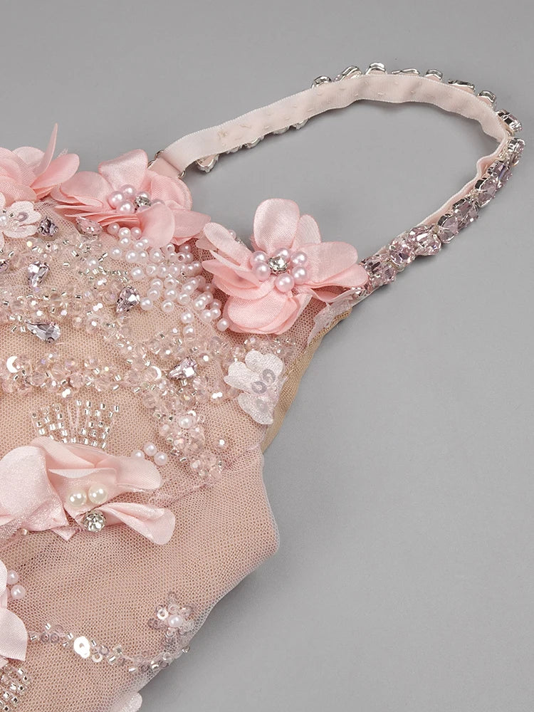 Decorative headband with pink flowers and beads on a gray background