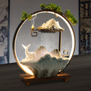 Decorative lamp with mountain, deer, and water features on a dark background